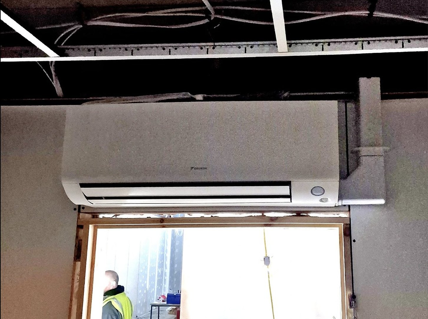 Daikin wall unit installed above a doorway by Cooling and Heating Space