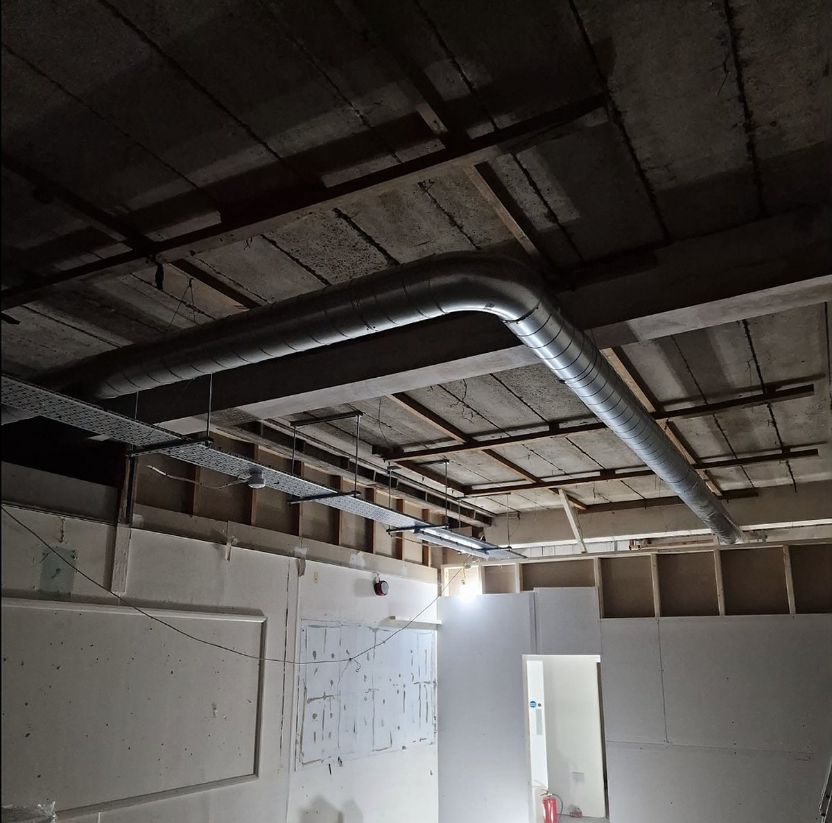 Exposed spiral ductwork run installed in a commercial ceiling by Cooling and Heating Space